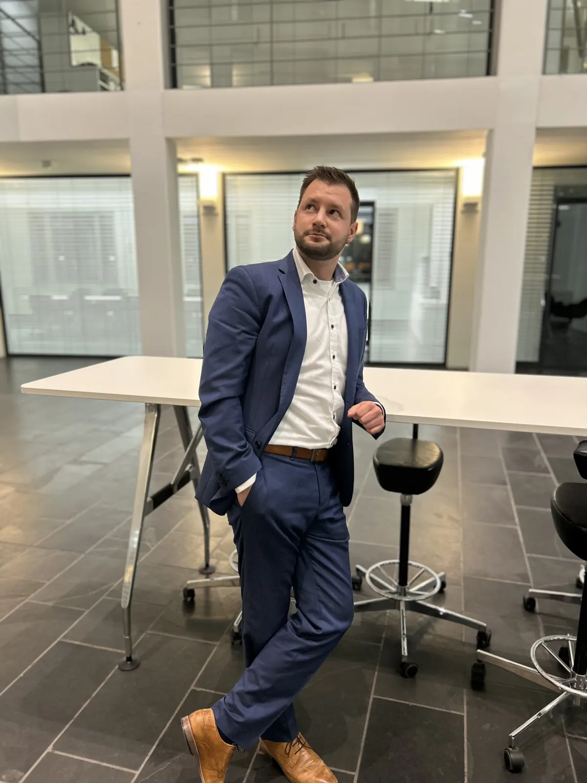 Sascha Heinz lehnt an einem Stehtisch im Bürogebäude